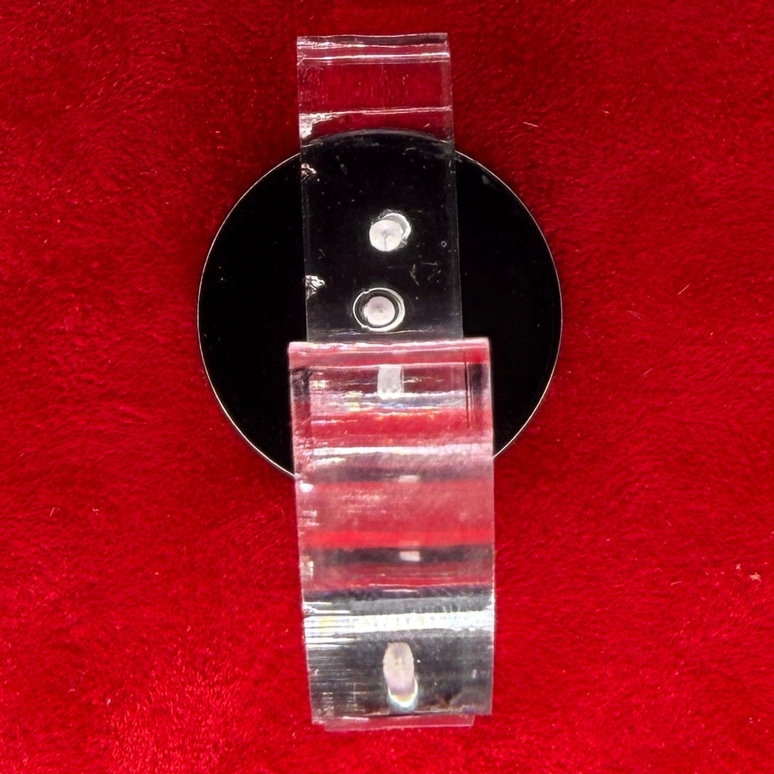 A clear acrylic sword  or staff holder with a black circular base, 